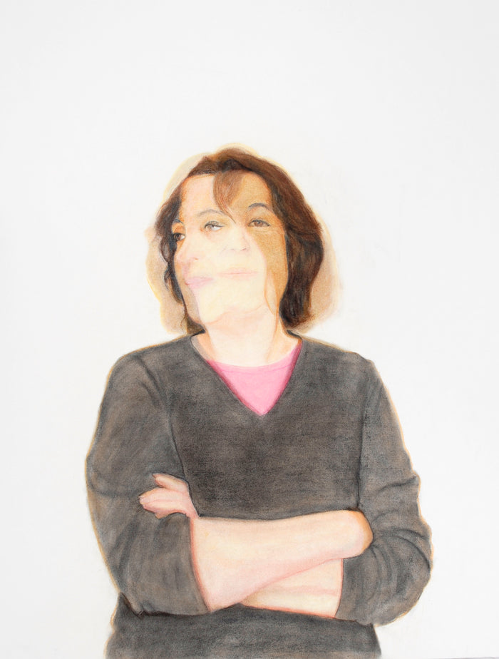 portrait of a woman in a gray v-neck sweater with a pink t-shirt underneath; her arms are crossed; the image of her face shows motion, looking forwards and to the left; she is on a white background