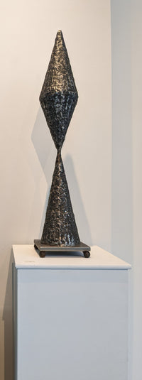 steel sculpture with a cone shaped base and a diamond shaped top