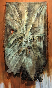 expressionist painting featuring hues of green and brown on burlap; in the center is an impression of a portrait that was burned into