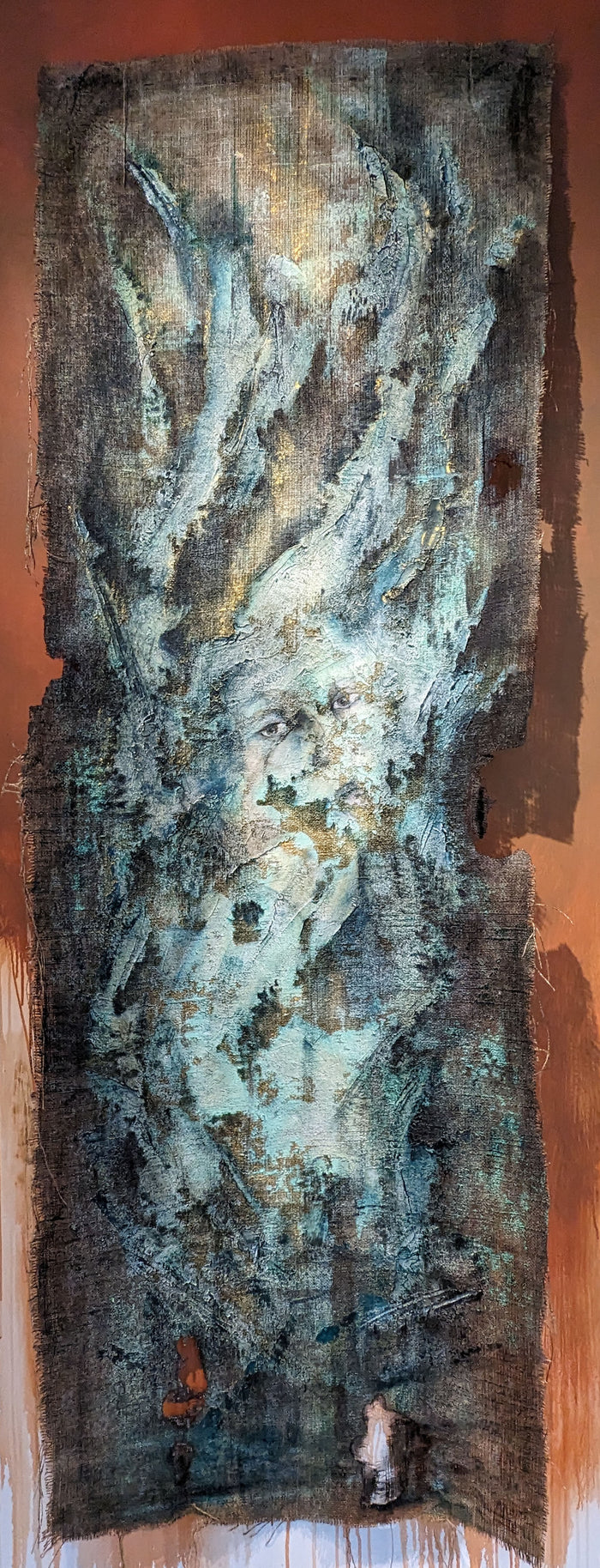 expressionistic painting featuring hues of green, blue and brown; hidden inside the painting is a portrait of a woman